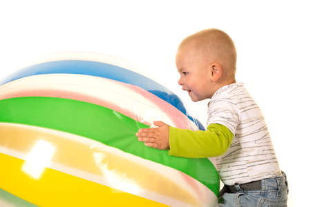 A young boy playing with a big beach ball.の写真素材