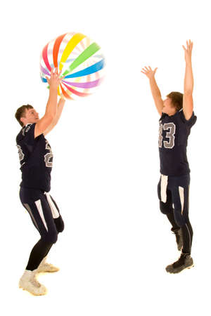 Two teen football players having some fun, playing with a beach ball.の写真素材