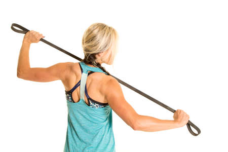 A woman's back stretching a band to make it stronger.の写真素材
