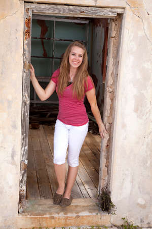 a girl in the door way with a big smile.の写真素材
