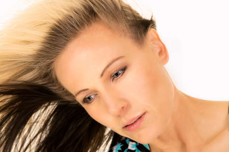 A close up of a woman's face with her hair blowing in the wind.の写真素材