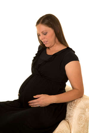 A pregnant woman looking down at her belly.の写真素材