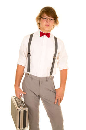 a young man with a serious expression on his face, holding on to his case.の写真素材