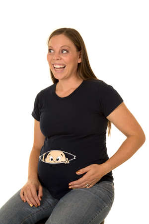 A pregnant woman with a funny shirt on with a funny expression on her face.の写真素材