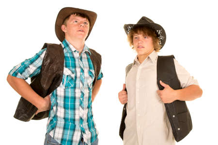 Two teen cowboys leaning back and wearing their vestsの写真素材