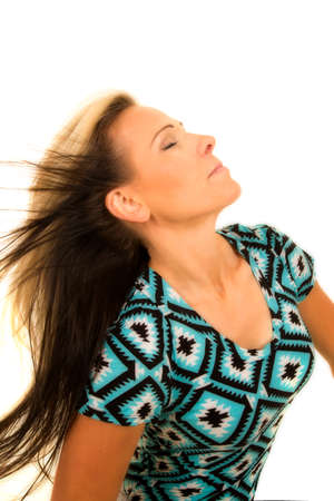 A woman with her hair being blown leaning back and enjoying the breeze.の写真素材
