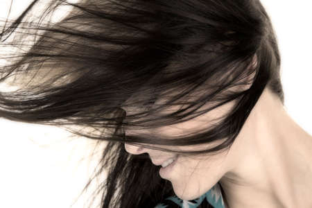 A  close up of a woman's hair flying over her face, she has a smile.の写真素材