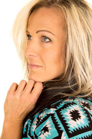 A blonde woman looking up with her hand under her chin.の写真素材