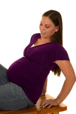 A pregnant woman looking down at her belly.の写真素材