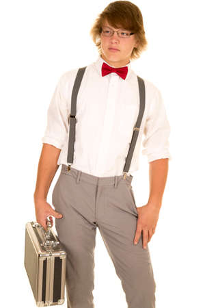 A young man in his dress clothing holding on to his case with a serious expression.の写真素材