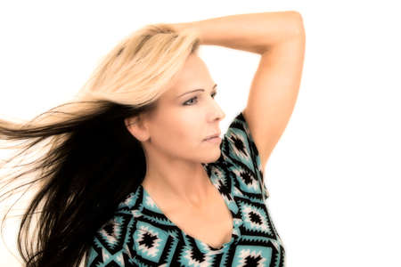 A woman looking to the side, while her hair is being blown.の写真素材