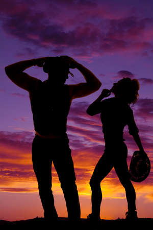 A silhouette of a cowboy with his cowgirl in the outdoors.の写真素材