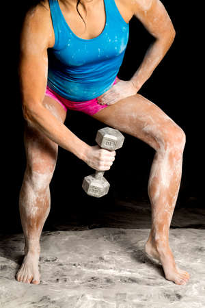 A woman leaning over covered in powder with weight.の写真素材