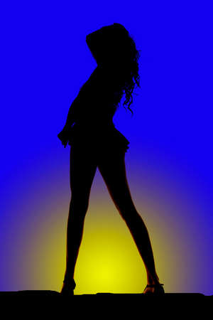 A silhouette of a woman standing in a very short skirt.の写真素材