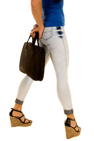 a woman in her denim jeans with her briefcase in her hands.の写真素材