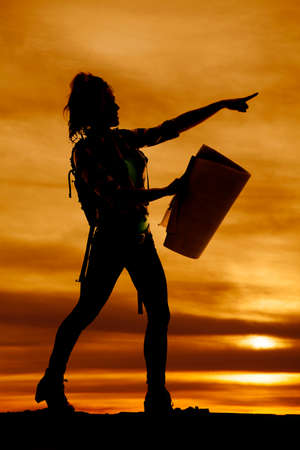 a silhouette of a woman hiker, with a map pointing in the direction to go.の写真素材