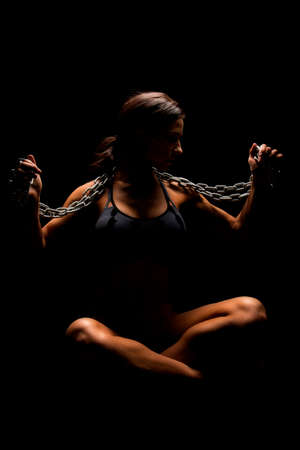 A woman in a black and gray sports bra with a chain around her neck.の写真素材