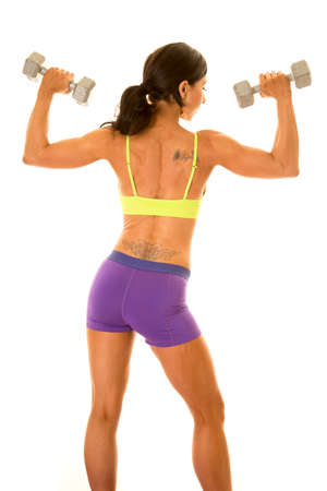 a woman's back showing off her muscles working out with weights.の写真素材