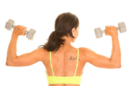 a woman's back working out with weights, with a tattoo.の写真素材