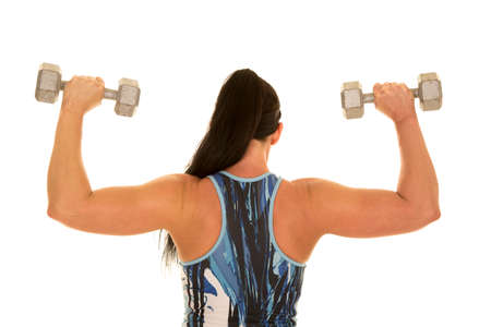 a woman working out with weights, working out her shoulders and back.の写真素材