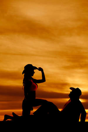 A cowboy laying back and his cowgirl kneeling next to him.の写真素材