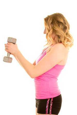 a woman standing sideways holding on to a weight.の写真素材