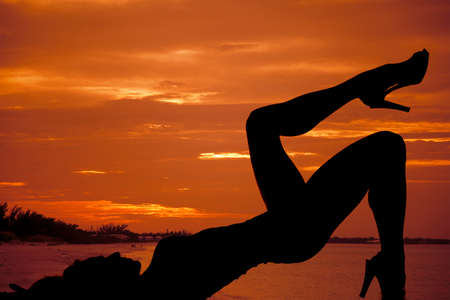 A silhouette of a woman relaxing on the beach.の写真素材