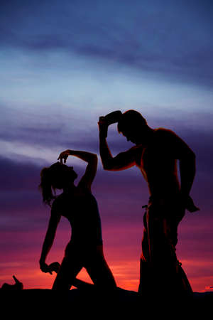 A silhouette of a woman looking up at her cowboyの写真素材