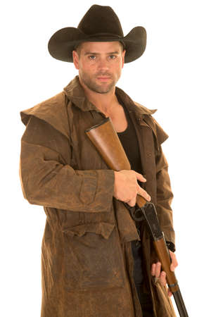 A cowboy in his western duster holding on to his rifle ready to shoot.の写真素材