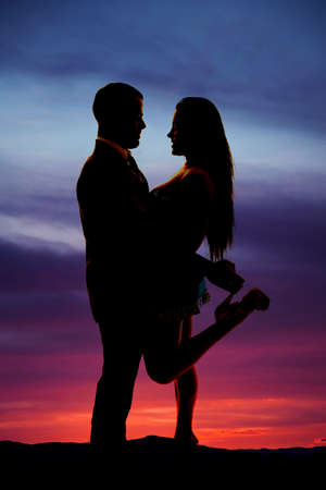 A silhouette of a couple holding on to each other close.の写真素材