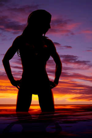 A silhouette of a woman in her bikini in the ocean water.の写真素材