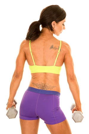 A woman's back working out with weights, with a tattoo on her back.の写真素材