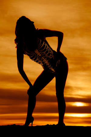 A silhouette of a woman in her skeleton swim suit, in the outdoors.の写真素材