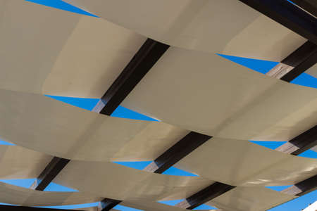 Detail of white pergola roof and blue sky.の写真素材