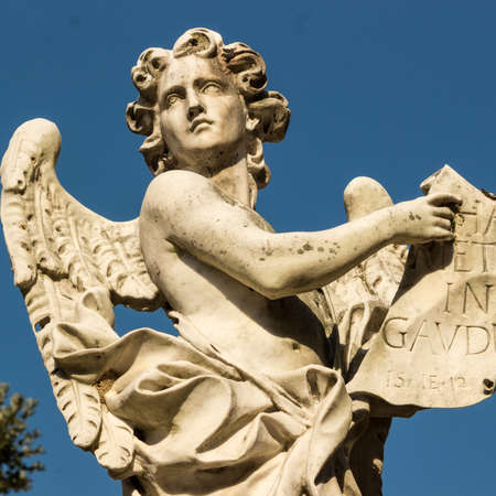 A statue of an angel with the table.の写真素材