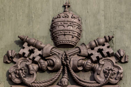 the emblem of the Vatican on green door of the church