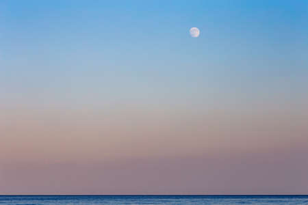 sunset and the moon on the warm Sicilian sea in late summerの写真素材