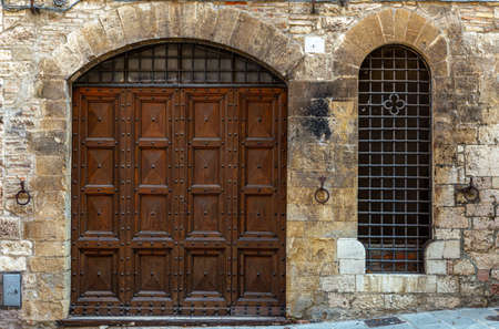 Italy: Old door on medieval stone wallの写真素材
