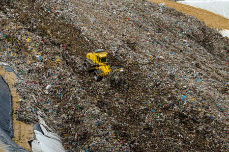 Yellow crawler vehicle in a garbage dump