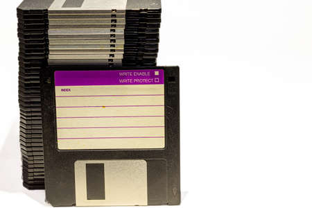 numerous black floppydisks lined up on a white backgroundの写真素材