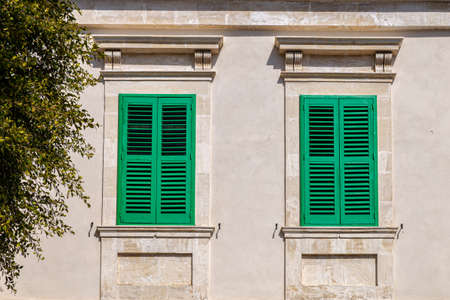 windows in the facades of ancient medieval housesの写真素材