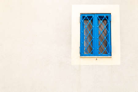 Window with blue railing on a light wall