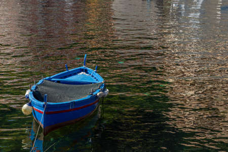 Sicilian fishing boat anchored in small Sicilian port