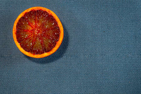 Detail of fresh sliced tarot orange on a rustic canvas fabric texture in blue woven colorの写真素材