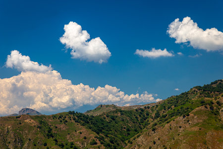 barren mountains, blue sky and white cloudsの写真素材