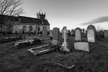 black and white landscape format of an old english church and graveyardのeditorial素材