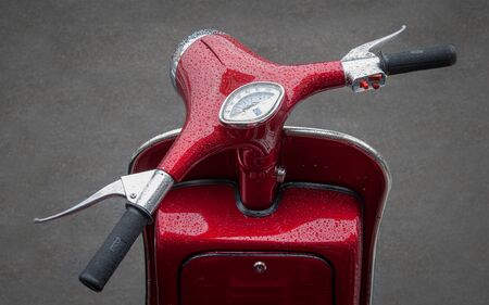 a red motor scooter handlebars complete with rain drops.の写真素材