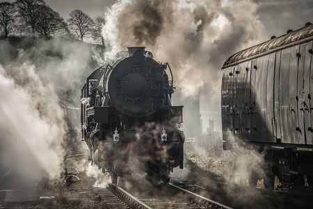 An early morning view of a steam train smoking and letting off steamの写真素材
