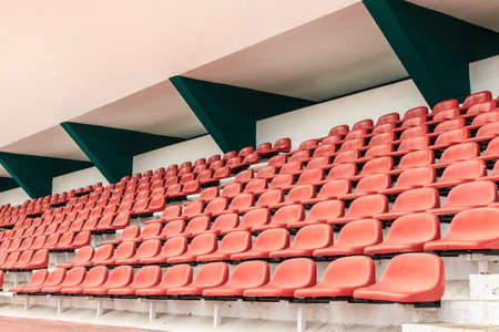 outdoors old red chairs in the stadiumの写真素材