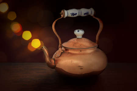 Old copper teapot with stream coming from the spout.の写真素材